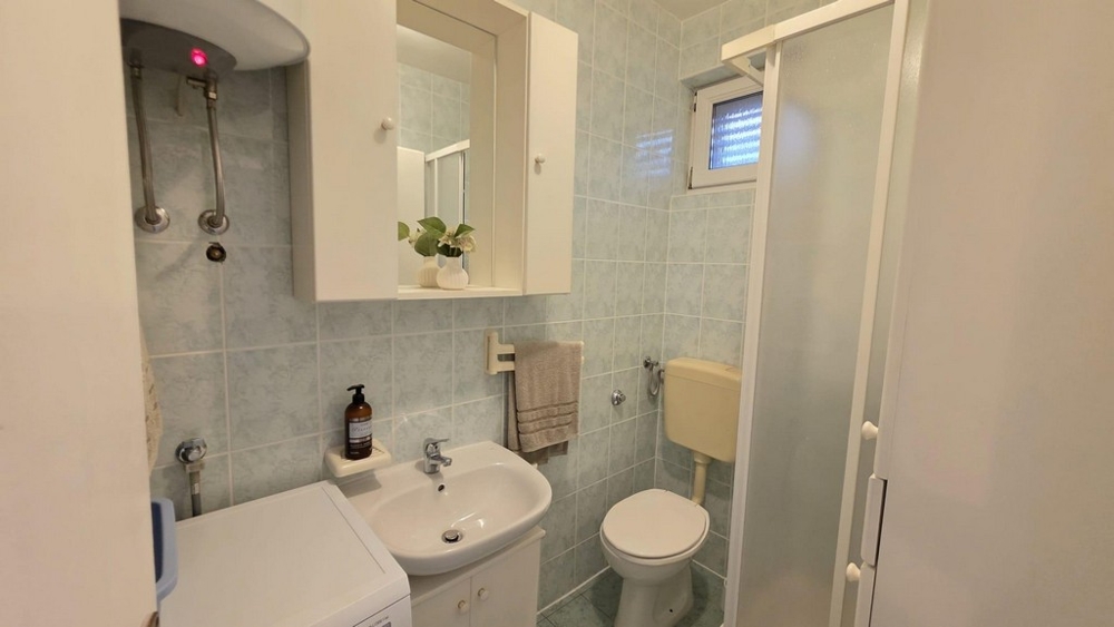 Badezimmer mit Dusche und Waschmaschine