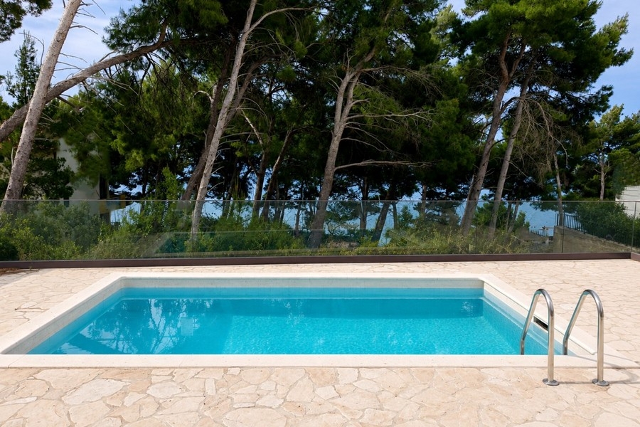Swimmingpool mit Terrasse und mediterraner Gartenanlage am Meer
