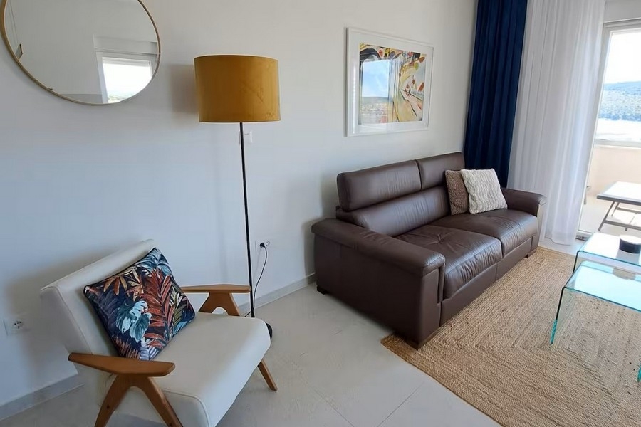 Heller Wohnbereich mit Ledersofa und Meerblick
