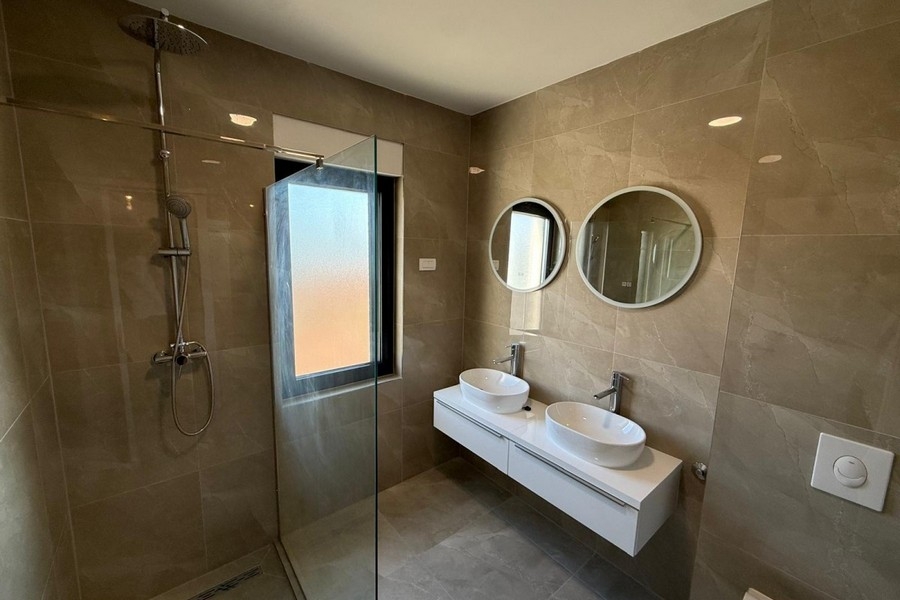 Badezimmer mit Doppelwaschbecken und Dusche