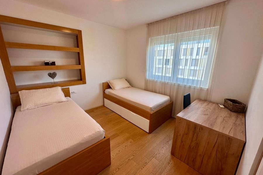 Zweites Schlafzimmer mit Einzelbetten und Regal
