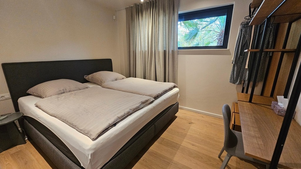 Schlafzimmer mit Doppelbett und Fenster