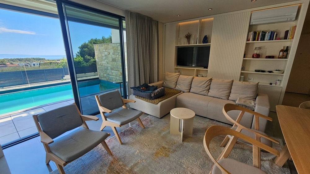 Modernes Wohnzimmer mit Blick auf Pool und Meer