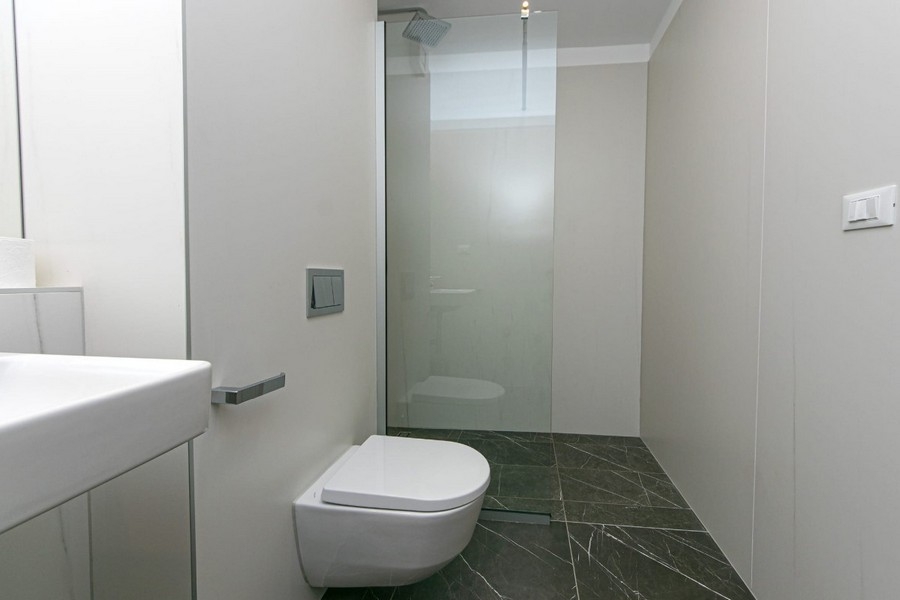 Badezimmer mit ebenerdiger Dusche und WC