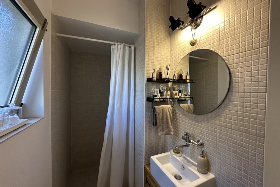 Badezimmer mit Waschbecken und Spiegel