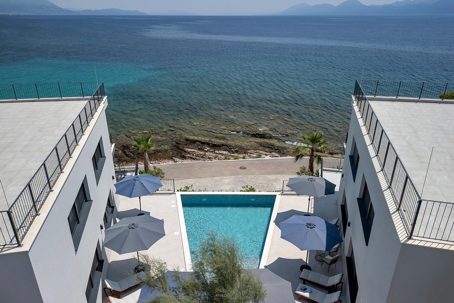 Luftaufnahme des Apartments mit Pool am Meer