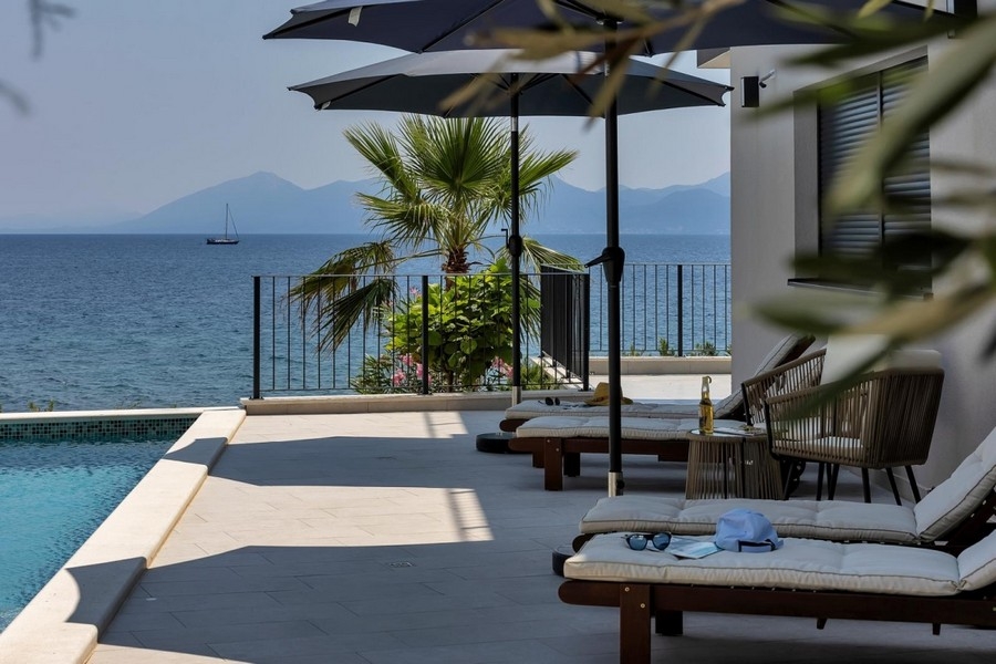 Poolterrasse mit Palme und Blick aufs Meer