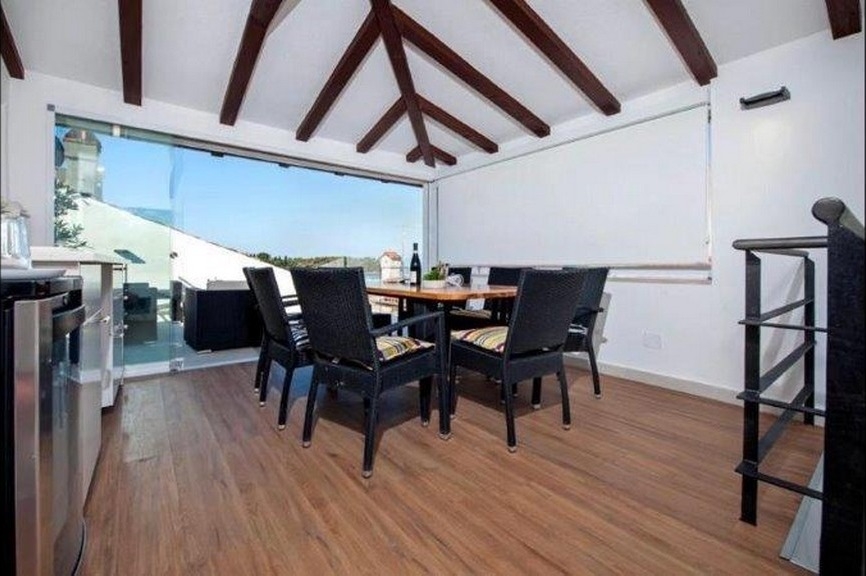 Essbereich mit Holzbalkendecke und Terrassenzugang