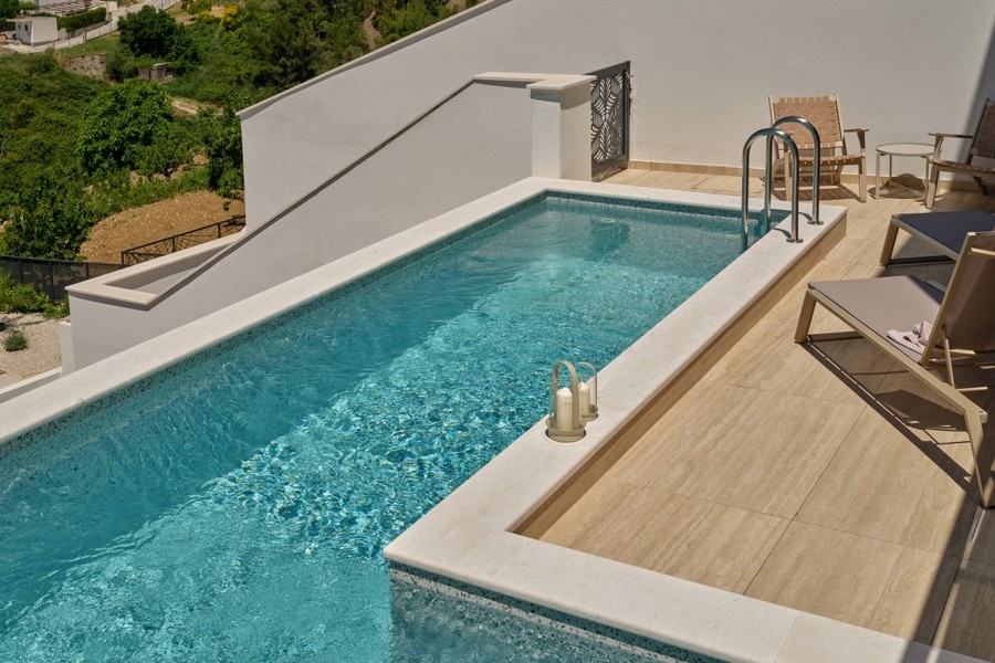 Poolbereich mit Sonnenliegen und Terrasse