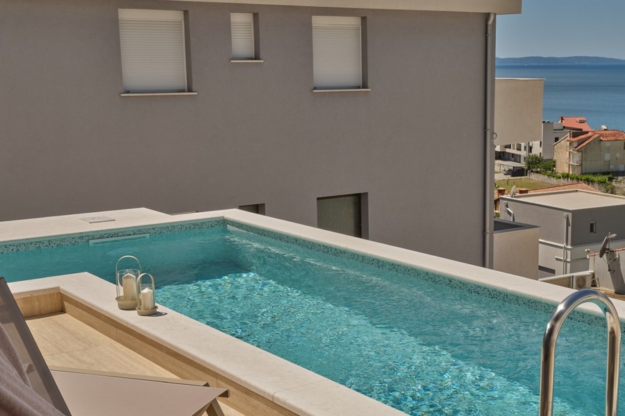 Pool mit Villenfassade und Meerblick in Kroatien