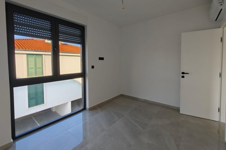 Raum mit Fenster und Blick auf rote Dächer