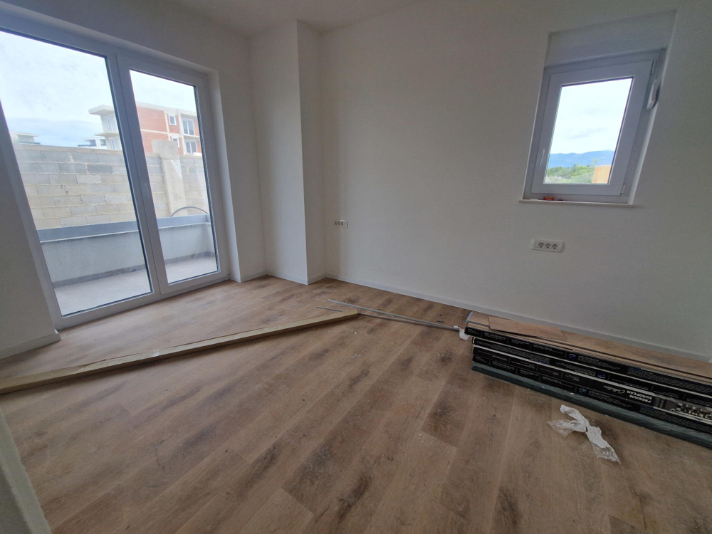 Zimmer mit Holzboden und Terrassenzugang