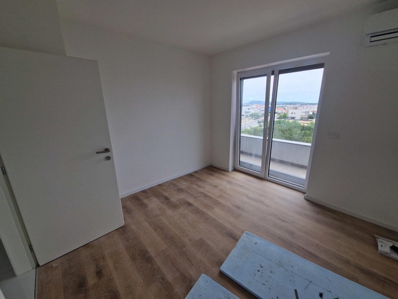 Wohnraum mit Bodenbelag und großen Fenstern