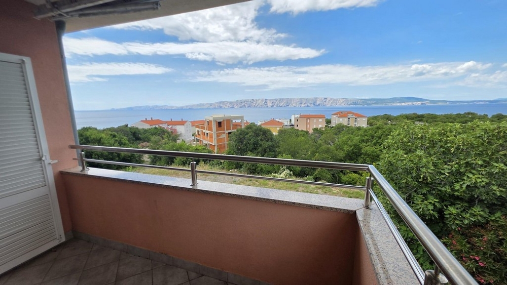 Blick vom Balkon über Grün auf das Meer