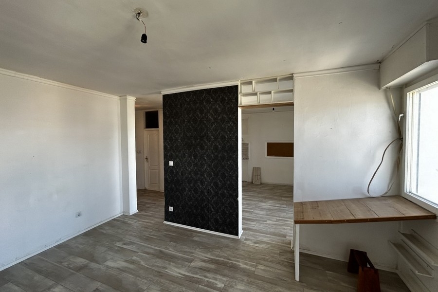 Wohnbereich mit Laminatboden und bodentiefem Fenster