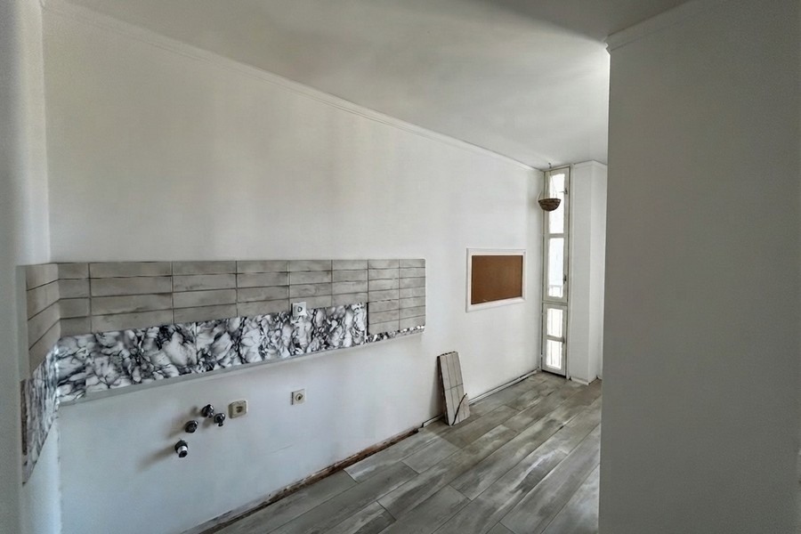 Kochbereich mit gefliester Wand und Fenster