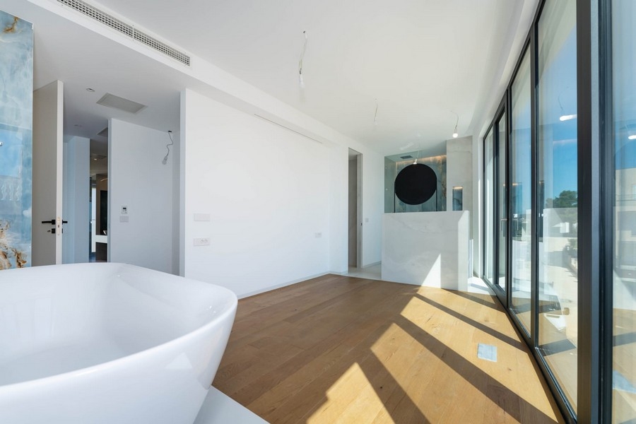 Badezimmer mit Badewanne und großen Fensterflächen