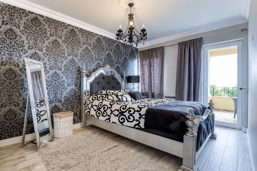 Schlafzimmer mit Ornamenttapete und Terrassenzugang