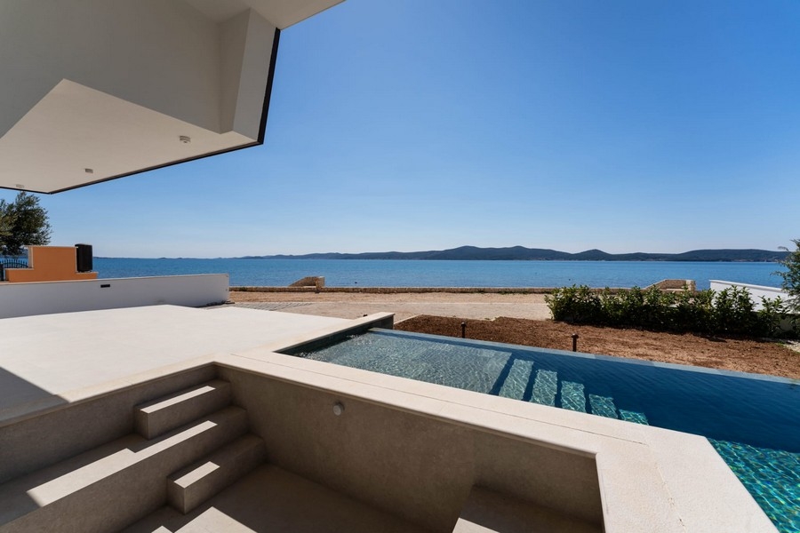 Überdachte Terrasse mit Stufen zum Pool und Meerblick