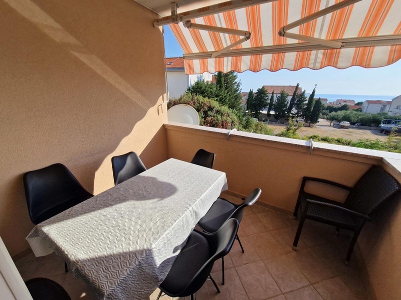 Loggia mit Tisch und Stühlen unter der Markise