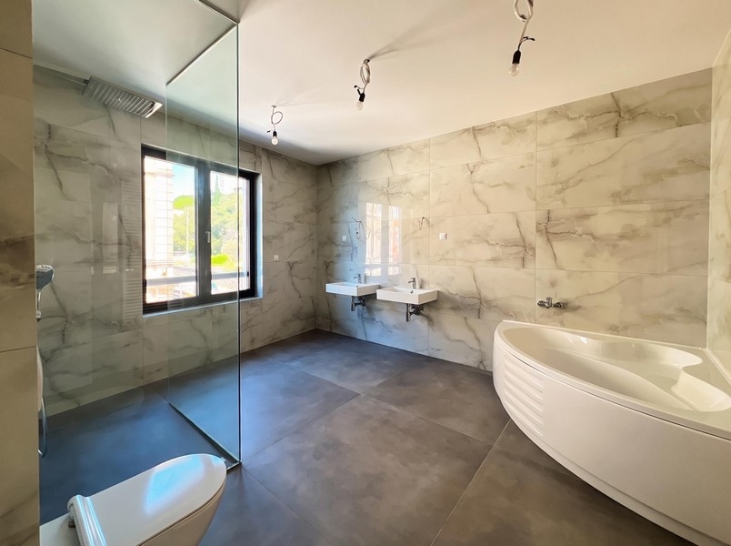 Badezimmer mit freistehender Badewanne in Marmoroptik