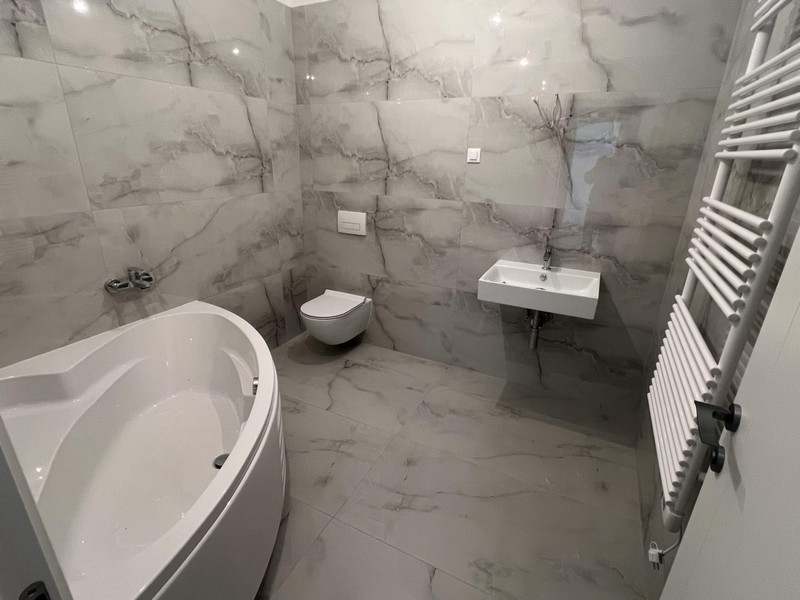 Badezimmer mit Badewanne in Marmoroptik