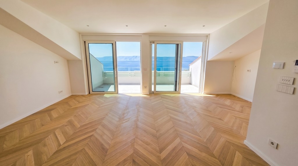 Wohnraum mit Fischgrätparkett und Terrassenzugang