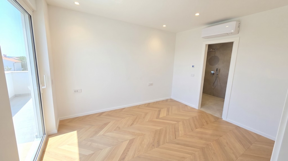 Schlafzimmer mit Klimagerät und Zugang zum Bad