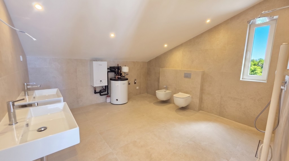 Badezimmer mit Fenster und Warmwasserbereiter