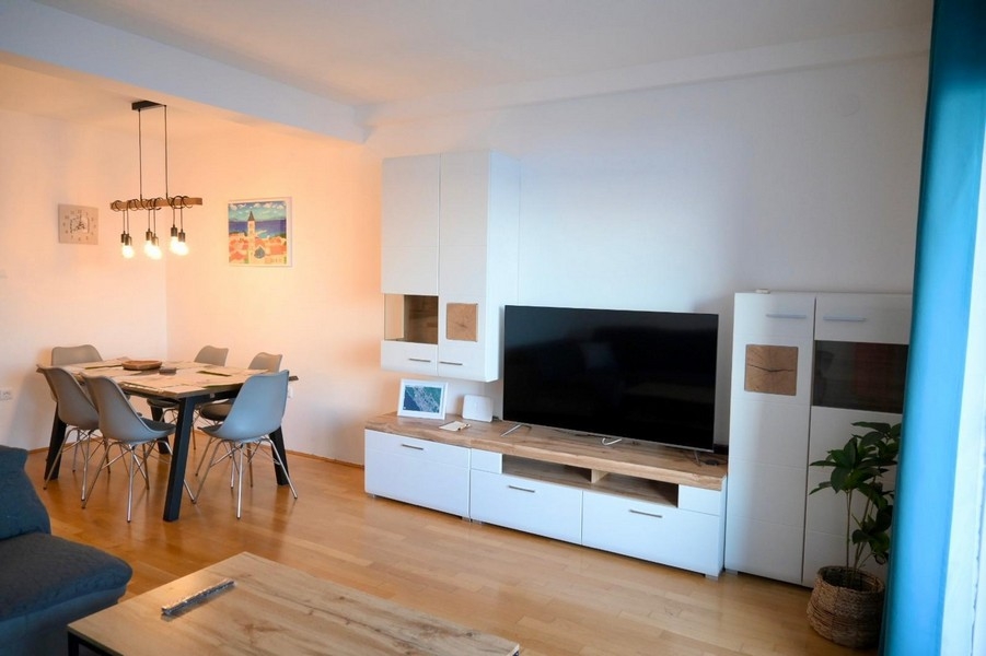 Wohnzimmer mit Esstisch und TV-Wand