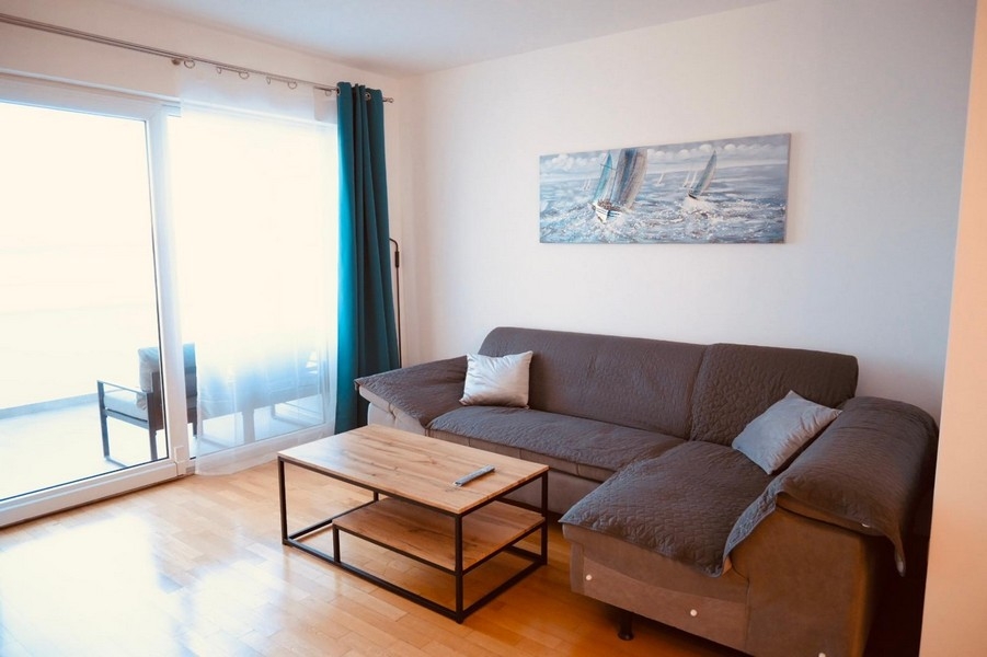 Wohnraum mit Sofa und Balkonzugang