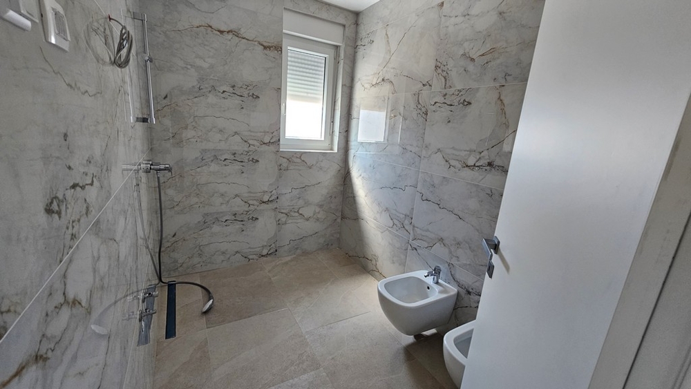 Modernes Badezimmer mit Dusche und Marmoroptik