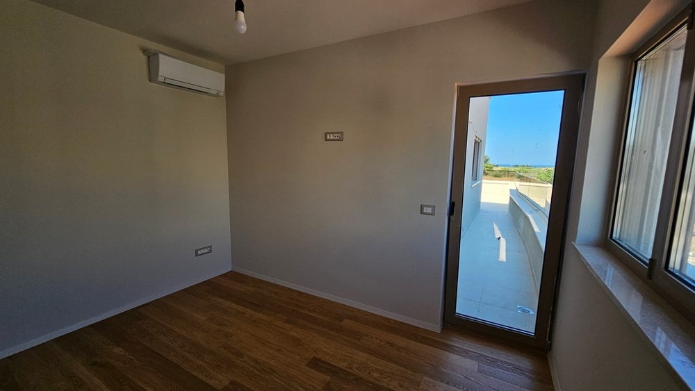 Schlafzimmer mit Terrassentür und Blick zum Meer