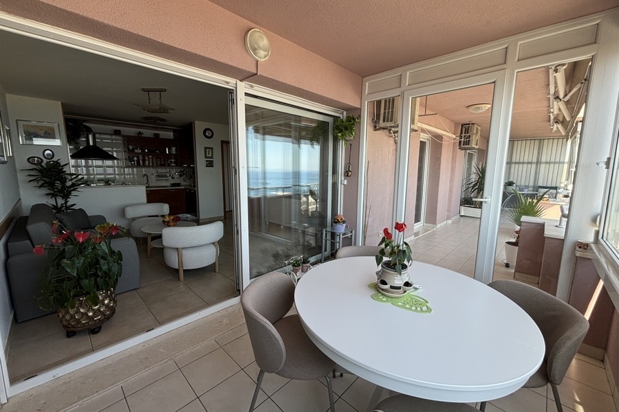 Loggia mit Tisch und Blick in den Wohnbereich