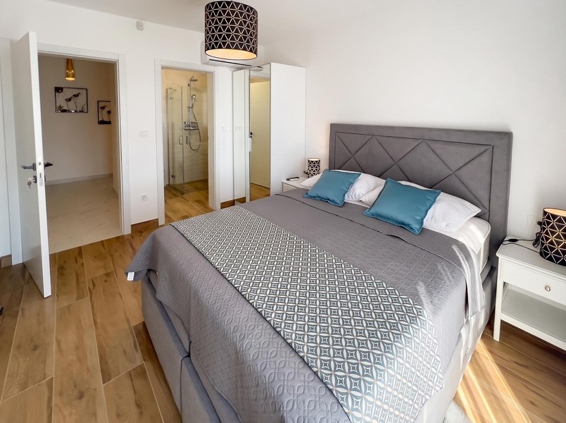 Schlafzimmer mit Doppelbett und angrenzendem Bad