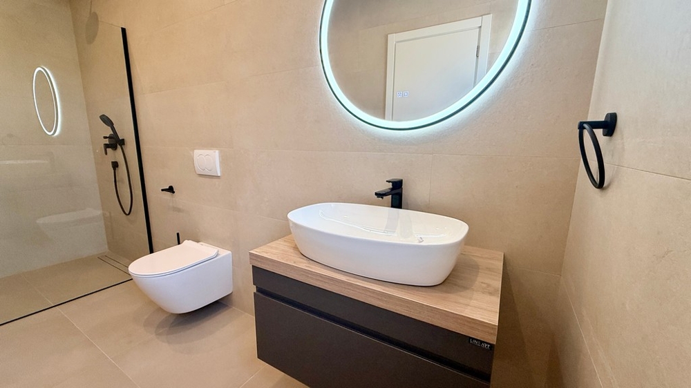Badezimmer mit rundem Spiegel