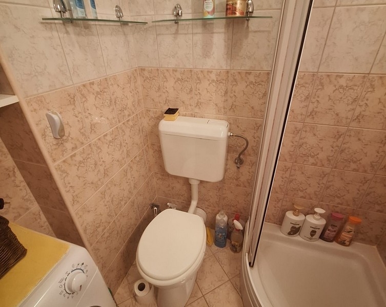 Badezimmer mit Dusche, Toilette und Waschmaschine
