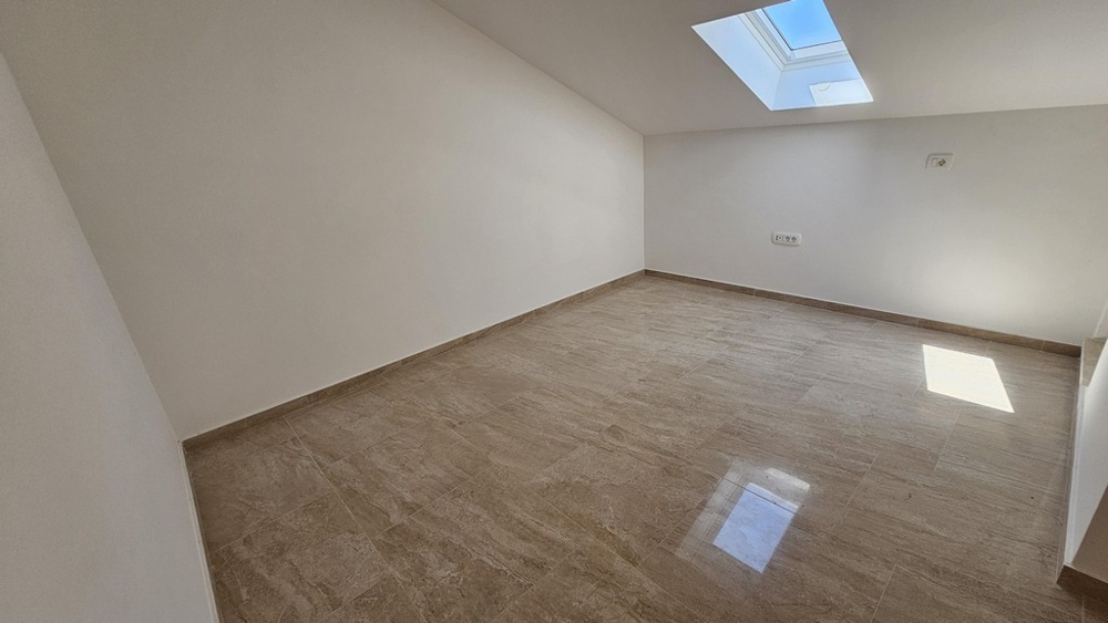 Raum mit Dachfenster und hellem Bodenbelag