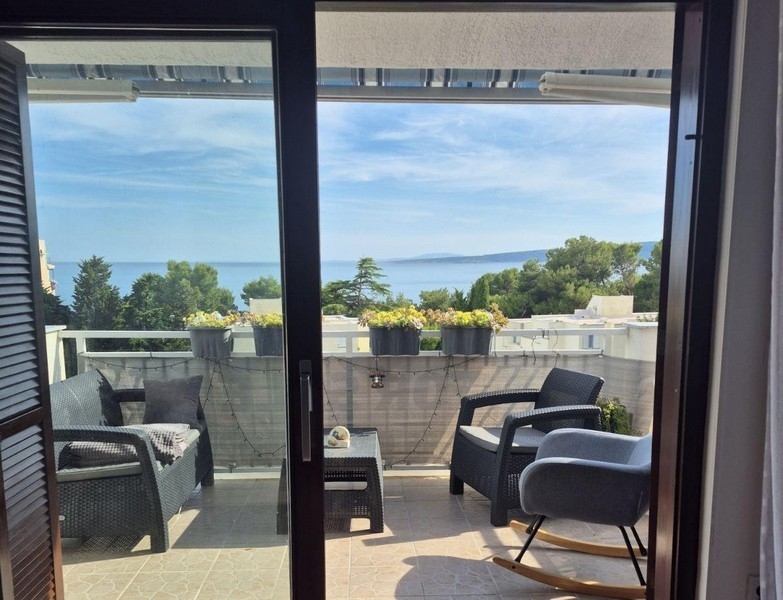 Blick vom Wohnraum auf Terrasse und Meer