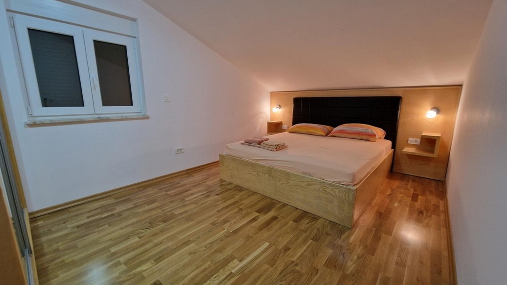 Schlafzimmer mit Doppelbett und Holzboden in Njivice auf Krk