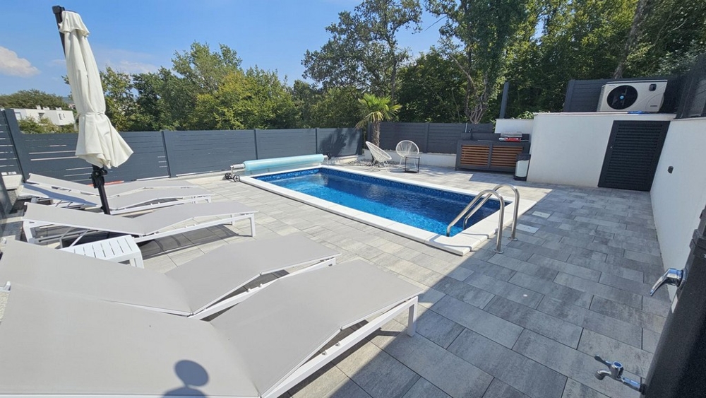 Garten mit beheiztem Pool und Sonnenliegen der Wohnung in Malinska