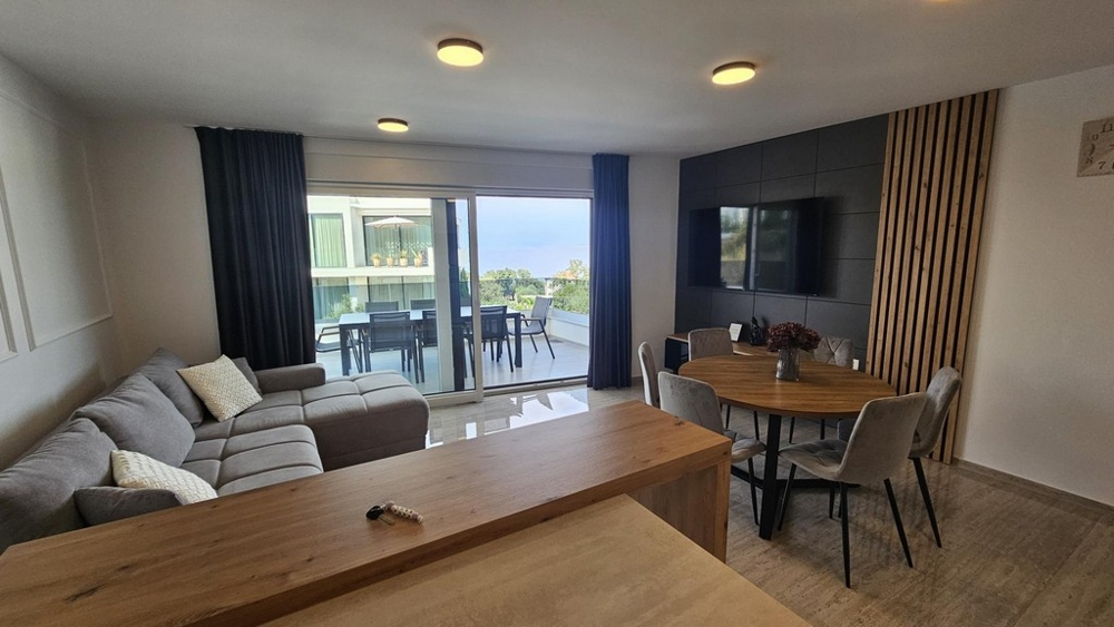Wohnzimmer mit Esstisch und Ausgang zur überdachten Terrasse