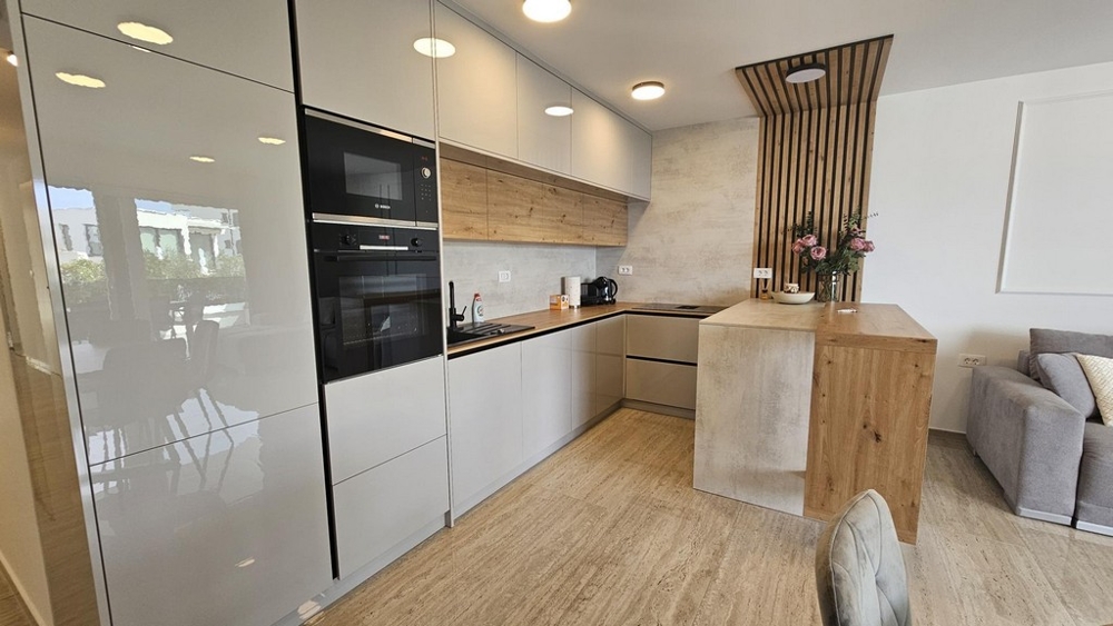 Moderne Einbauküche mit Hochglanzfronten und Holzelementen