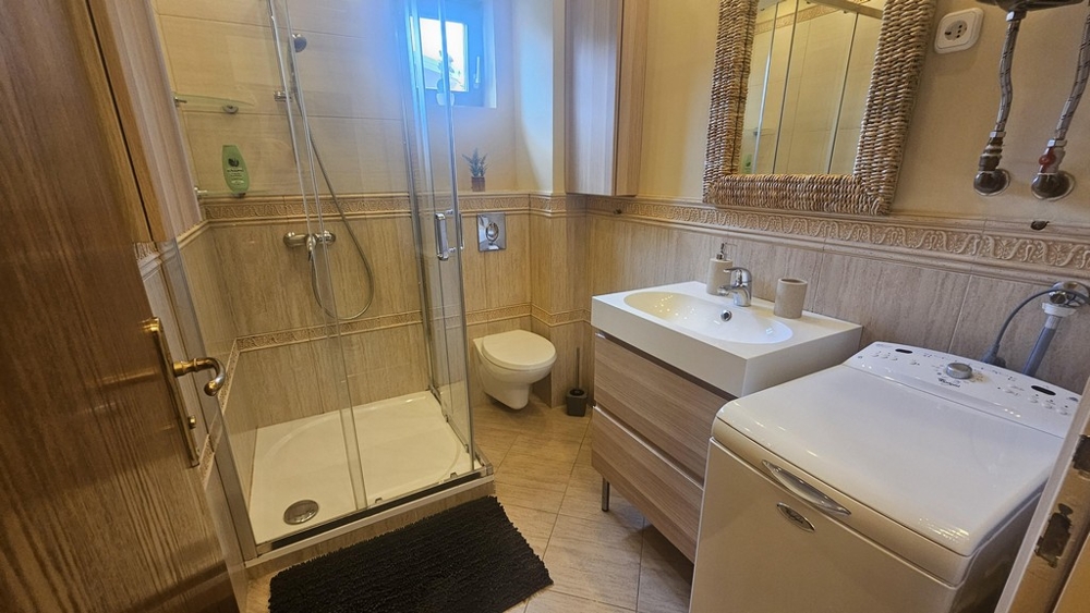 Badezimmer mit Dusche, Toilette und Waschmaschine