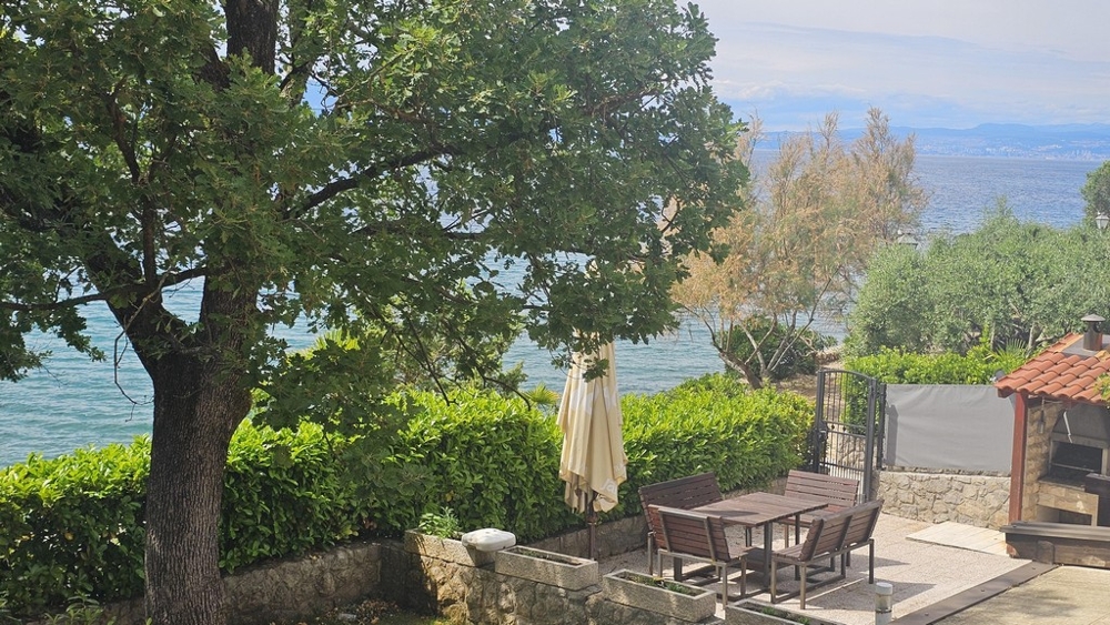 Terrasse am Meer mit Sonnenschirm und Sitzplatz in Malinska