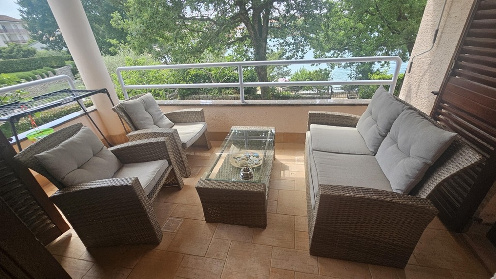 Überdachter Balkon mit Loungemöbeln und Meerblick