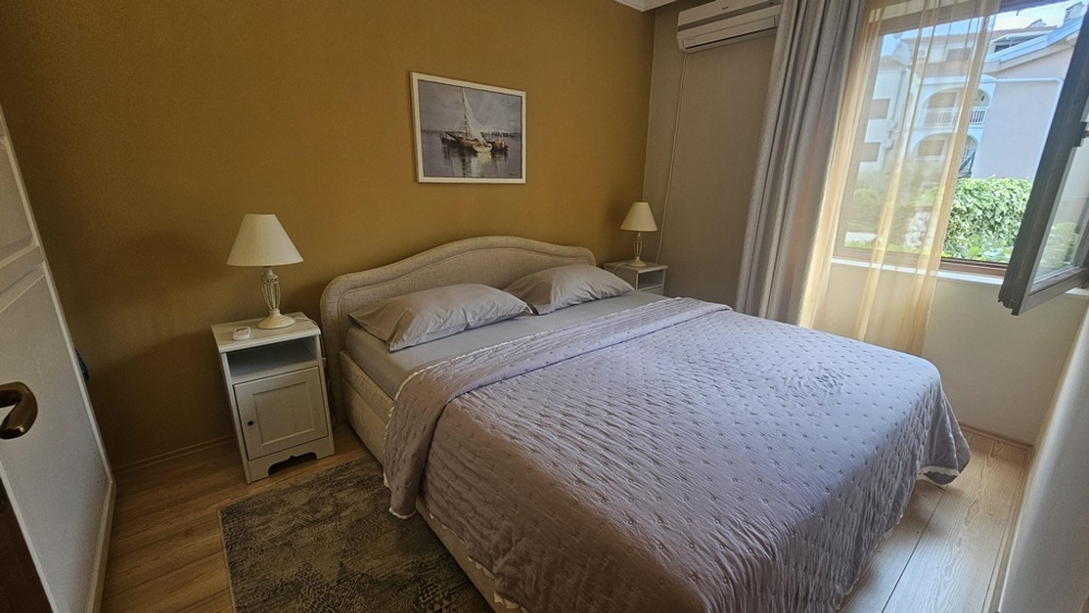 Schlafzimmer mit Doppelbett und Fenster zum Garten