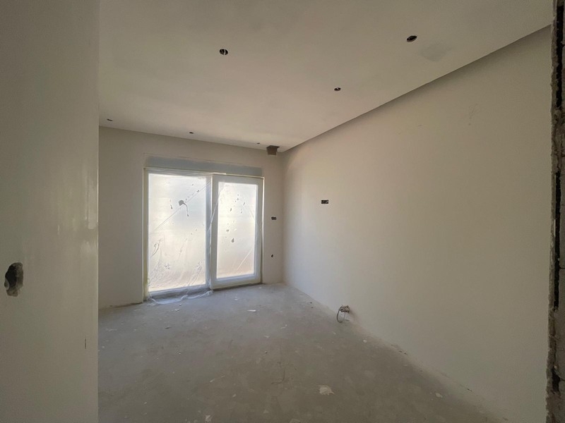 Zimmer des Penthouses mit Fenstertür zum Balkon
