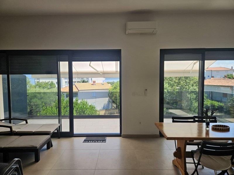 Essbereich mit Holztisch und Blick auf Balkon und Meer