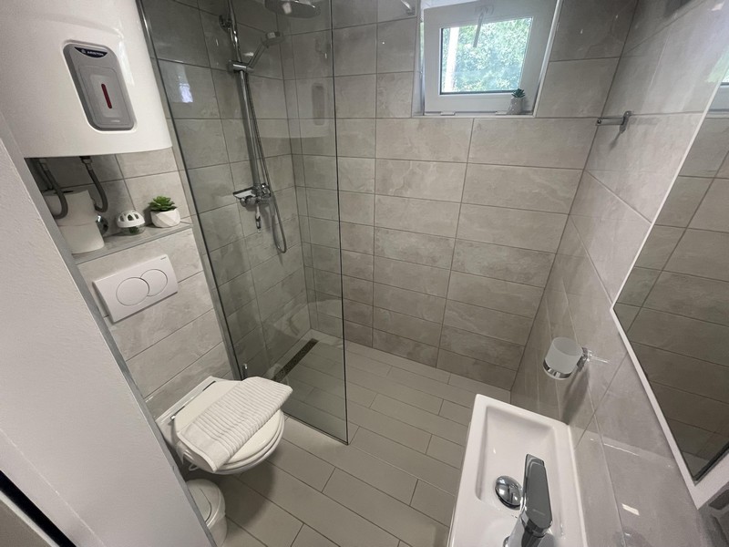 Badezimmer mit ebenerdiger Dusche in der Wohnung in Njivice